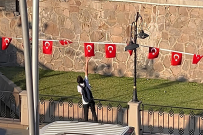 Rüzgarda ters dönen Bayrakları düzelten çocuk, yürekleri ısıttı