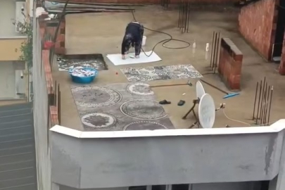 İlginç manzara: Yağmur altında çatıda halı yıkadı