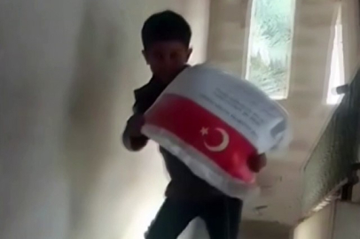 Kendi ağırlığı kadar un çuvalını taşıyan Filistinli çocuğun sevinci