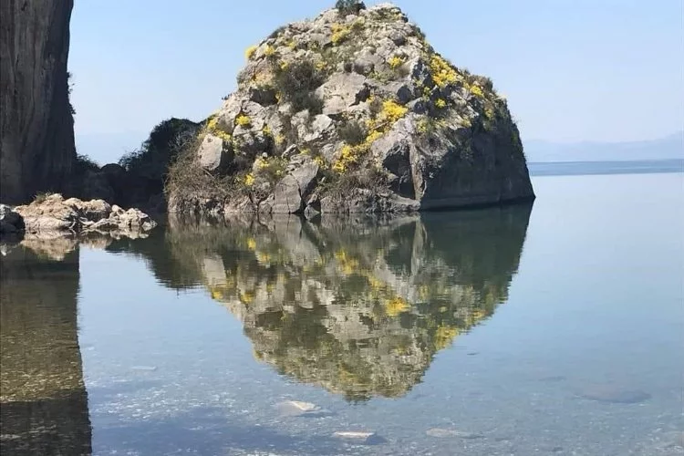Göle yansıyan kayada şok eden figür